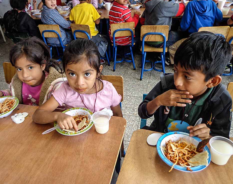 Guatemalan school children eating spaghetti for lunch