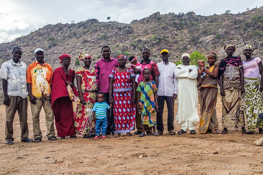 Cameroonian Christian families standing in a line in front of a hill