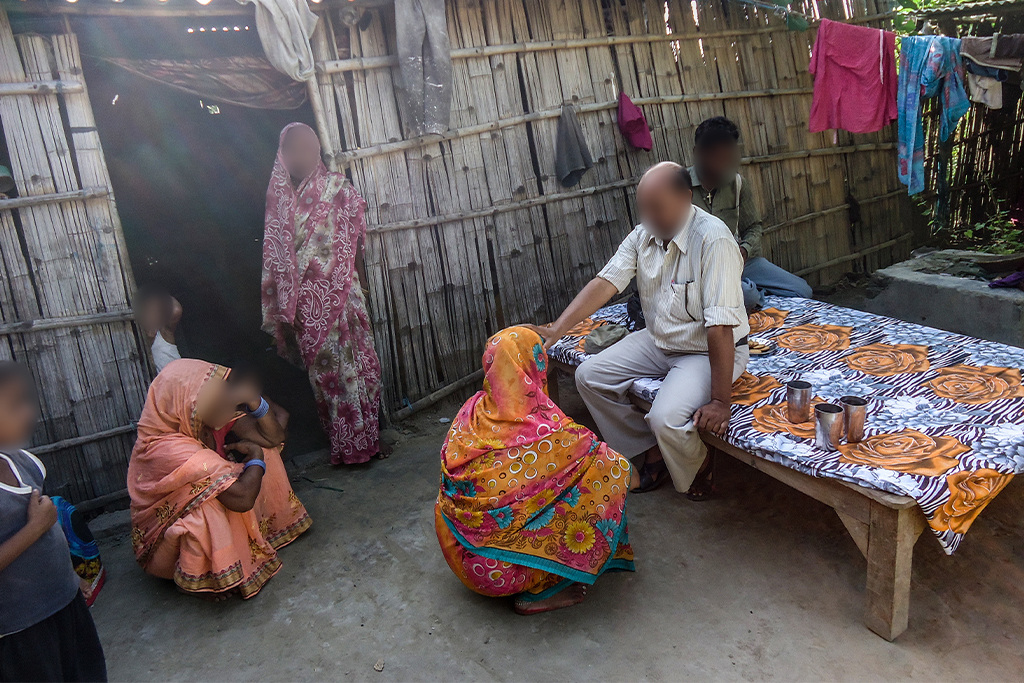 Christian missionary places his hand on the head of a woman to pray for her