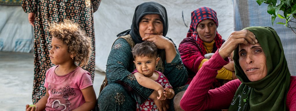 Turkish refugee mothers and their children sitting in a refugee camp in Greece