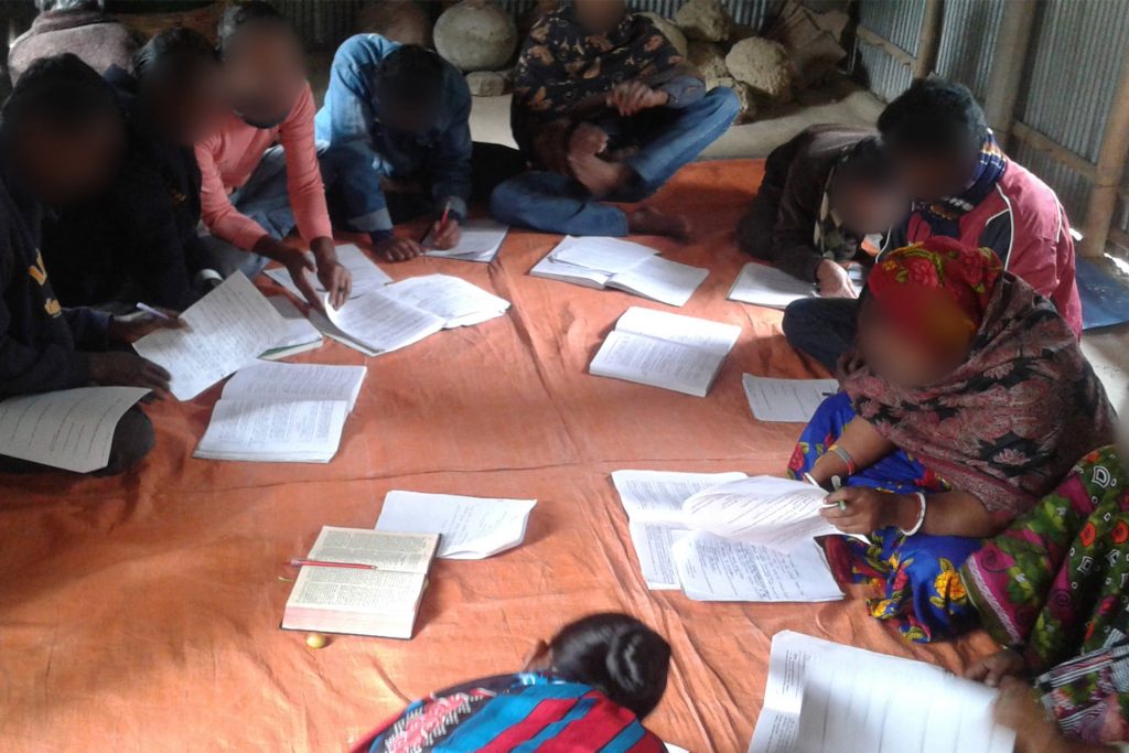 Christians in Bangladesh sit cross-legged on the floor of a bamboo and tin house going through a rigorous Bible study together