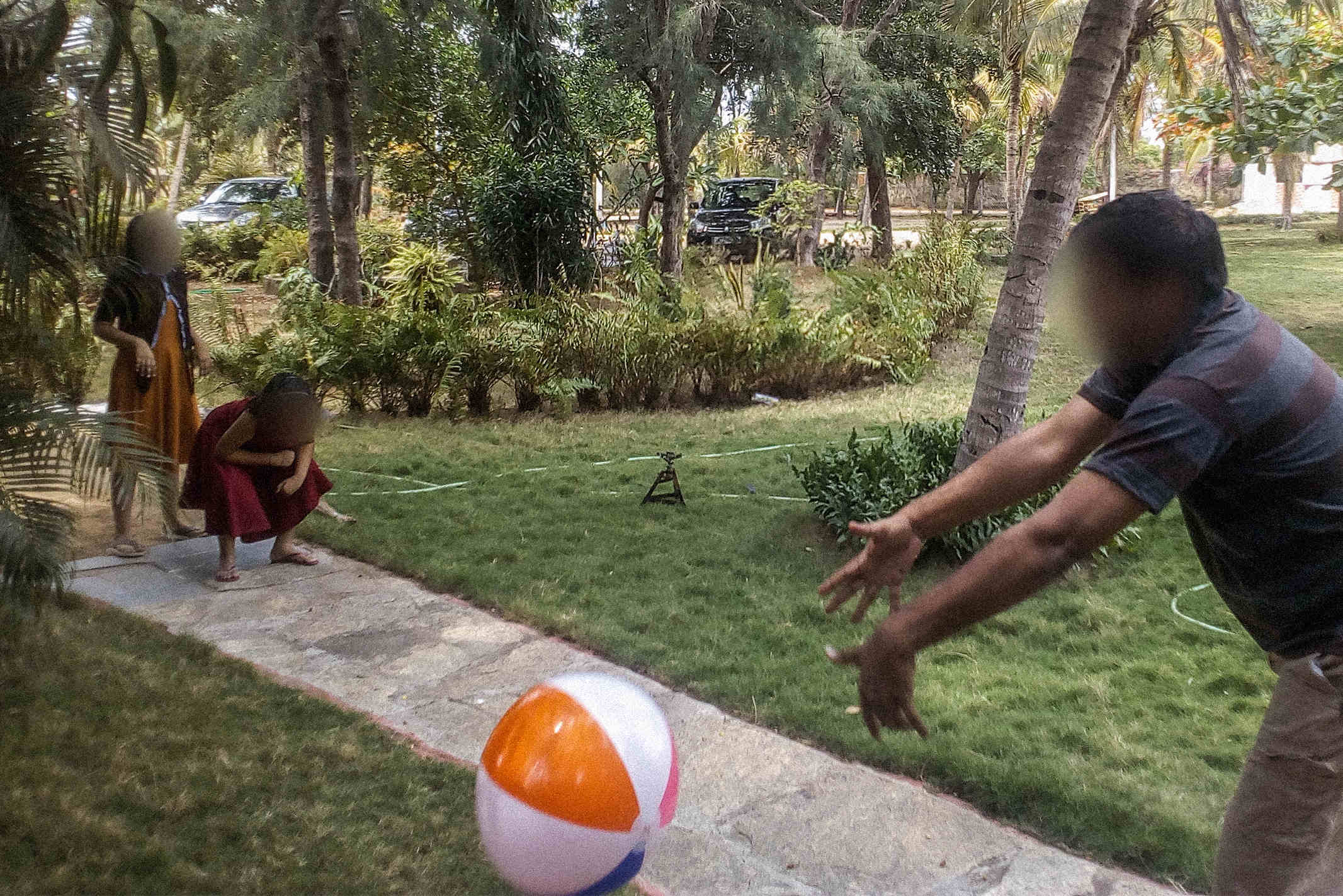 South Asian Christians playing outside in a grassy area with an inflatable beach ball