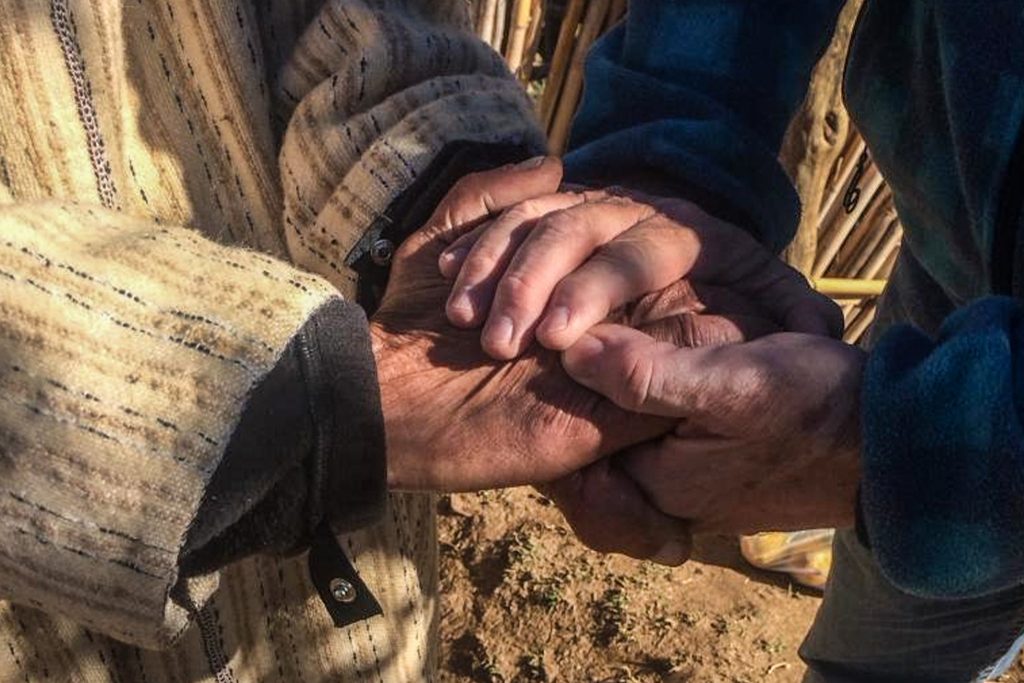 Refugee in Europe holding a missionaries hands