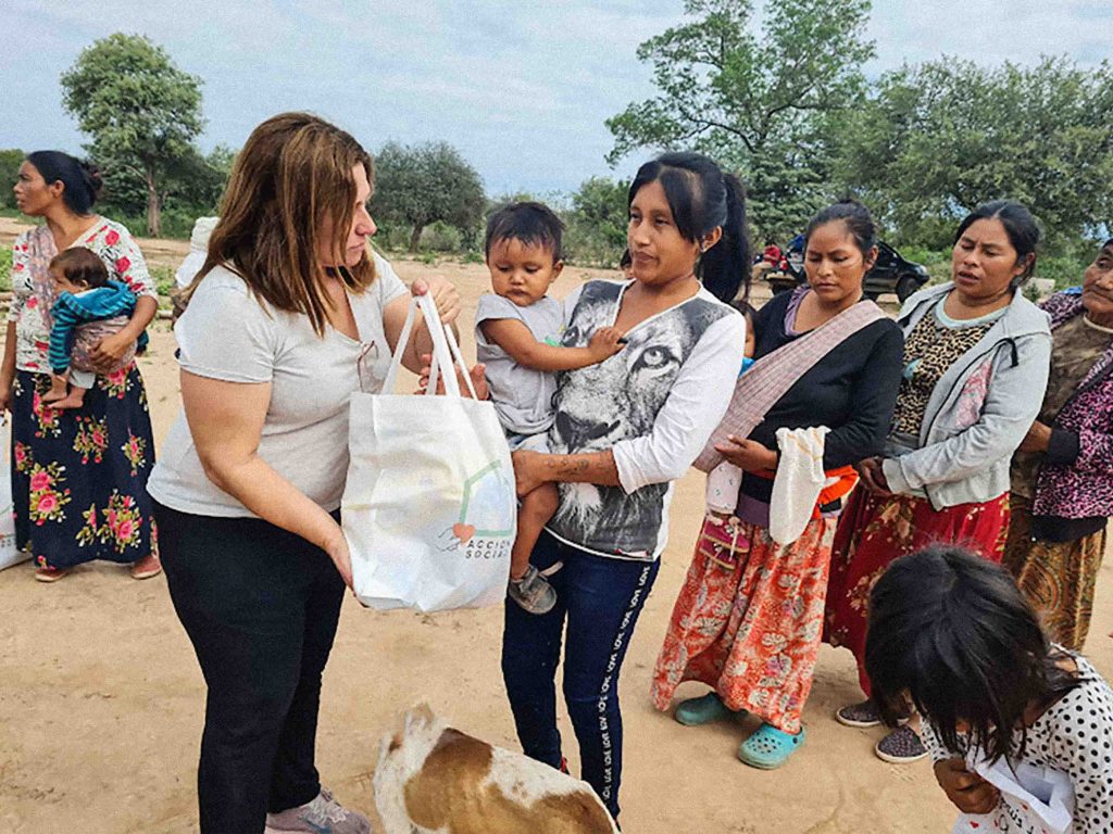 Christian missionary in Argentina hand goods to a line of Argentinian women