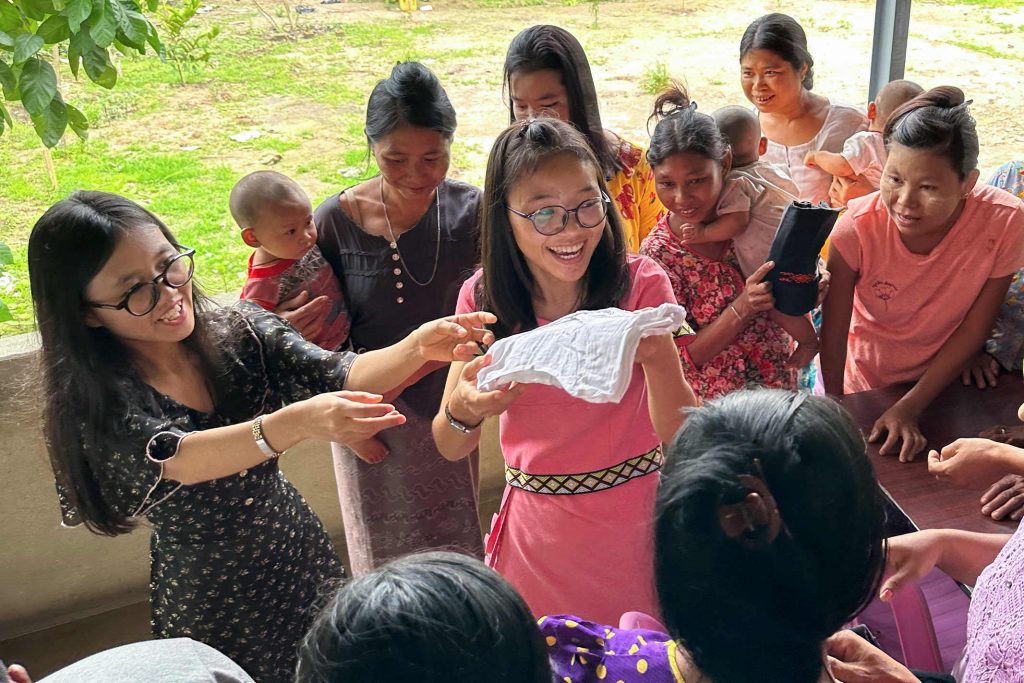 Women and girls in Burma receive much needed supplies under a pavilion