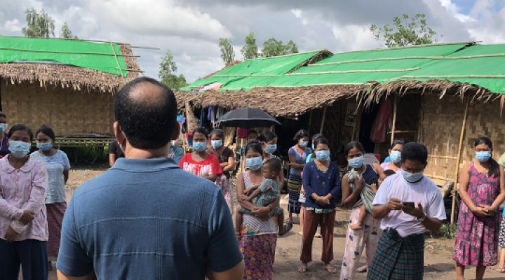 Lao women gather in front of their homes to hear the gospel proclaimed by a local Christian missionary