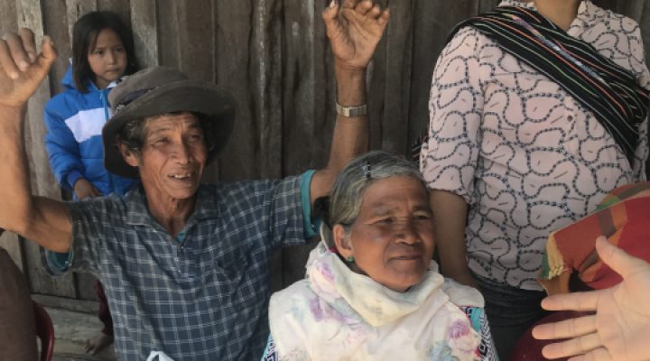 Christian missionary extends his hand to Vietnamese woman while others watch