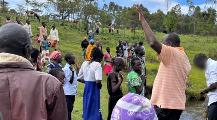 People from Kenyan town gather near riverbanks to pray with local Christian missionary