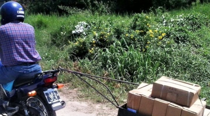 Argentinian Evangelist riding a motorcycle pulling a cart of packages